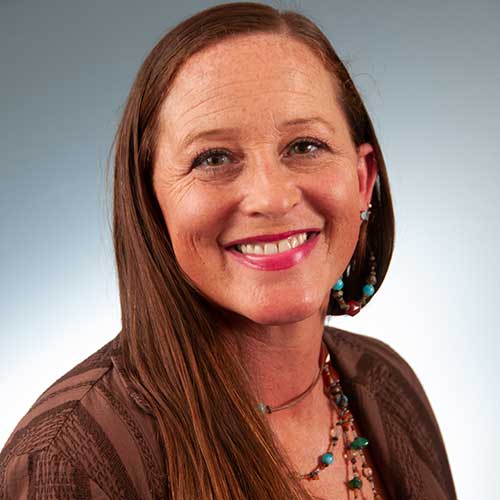 a woman wearing glasses and smiling at the camera