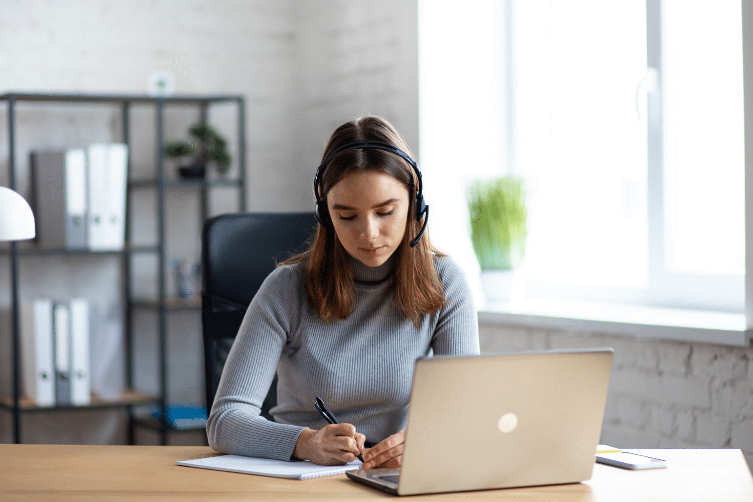 a woman sitting at a table using a laptop computer