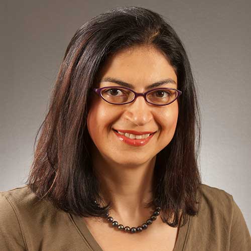 a person wearing glasses and smiling at the camera