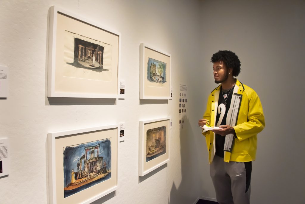 A visitor looks at sketches from a Theatre AUM play in the Winkelman exhibit on opening day.
