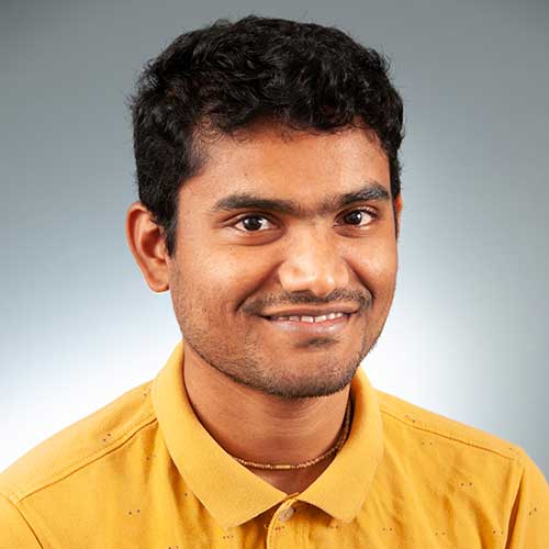 a man wearing glasses and smiling at the camera