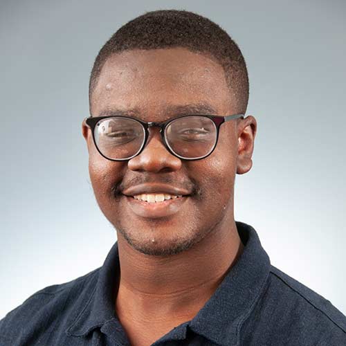 a man wearing glasses and smiling at the camera