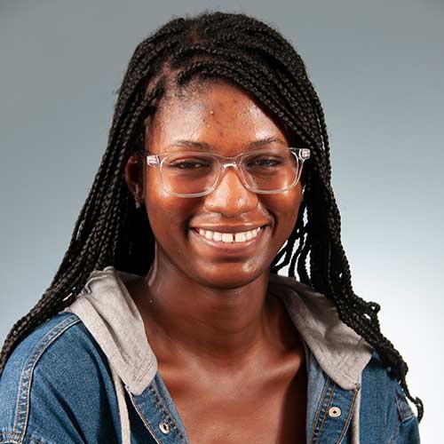 a person wearing glasses and smiling at the camera