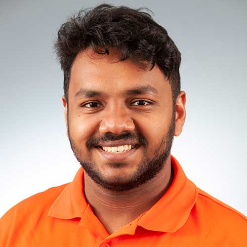 a man wearing an orange shirt and smiling at the camera