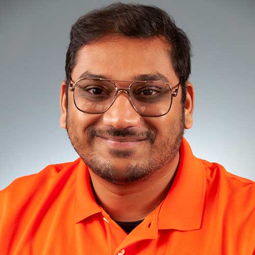 a man wearing glasses and smiling at the camera