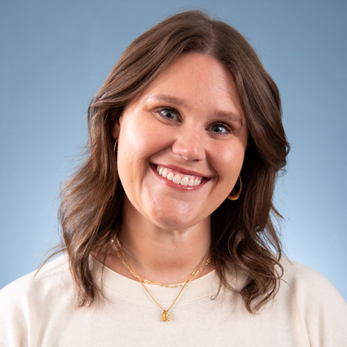 Smiling woman headshot on blue background for Auburn University at Montgomery (AUM)