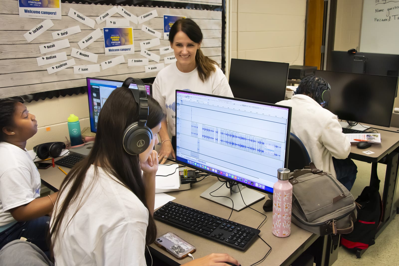 a group of people sitting at a desk in front of a computer