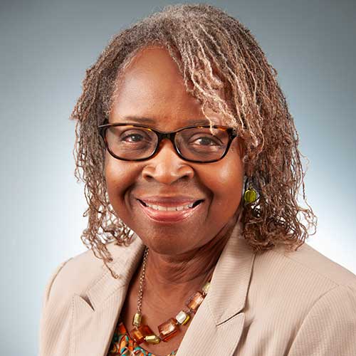 a woman wearing glasses and smiling at the camera