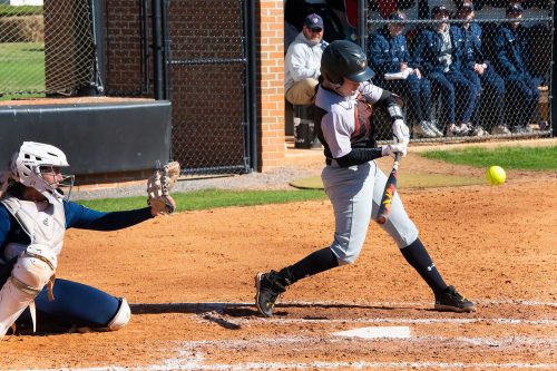 A Baseball Player Swinging A Bat At A Ball