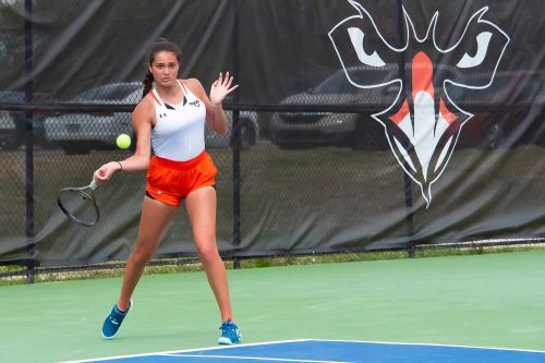 A Woman Hitting A Ball With A Racket