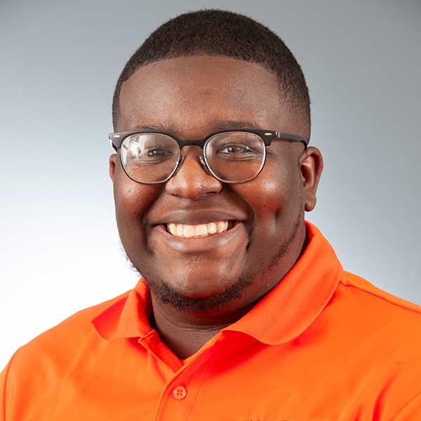 a man wearing glasses and smiling at the camera