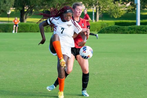 A Girl Holding A Football Ball On A Field