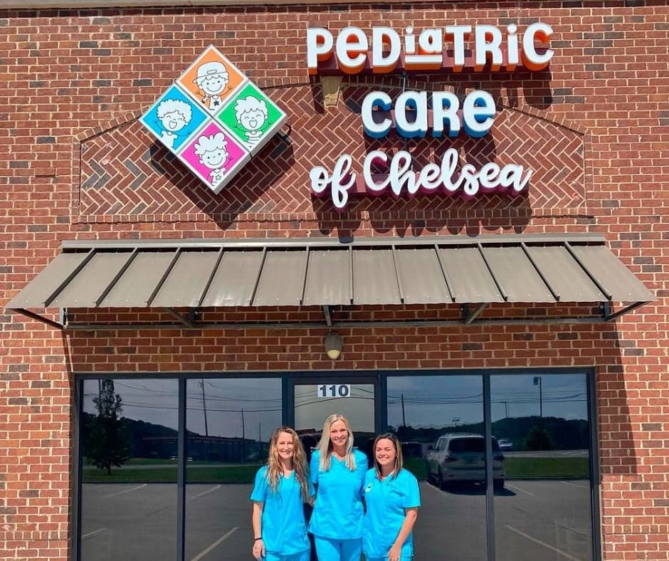 a group of people standing in front of a brick building