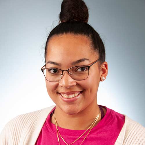 a person wearing glasses and smiling at the camera