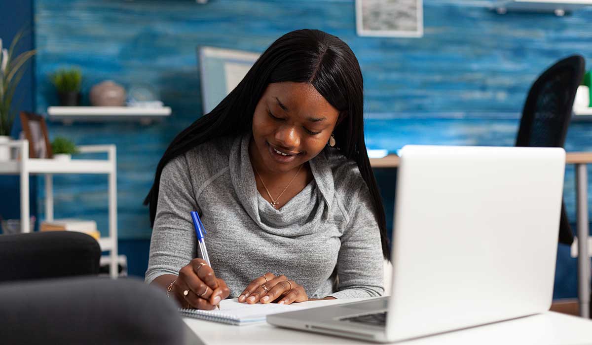 a woman sitting at a table using a laptop computer