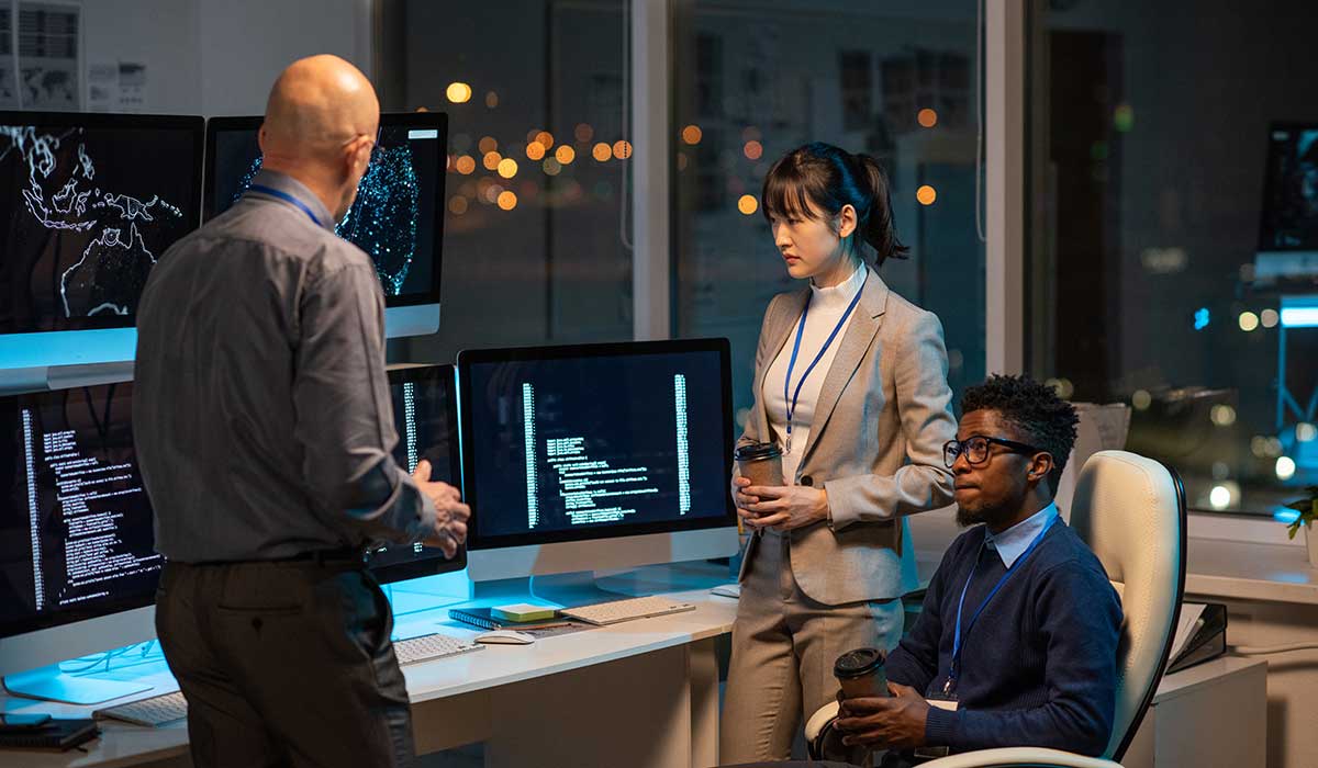 a couple of people that are standing in front of a computer