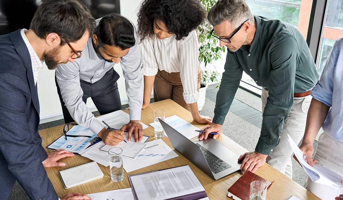 a group of people looking at a laptop