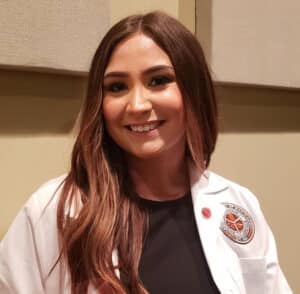 a woman wearing glasses and smiling at the camera