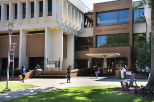Students walk around the Quad in front of the College of Business.