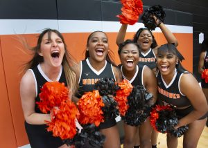 Cheerleaders cheer to the camera.
