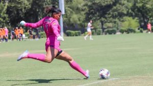 Karla Guzman-Ortiz kicks the ball back into play at women's first home game.
