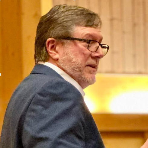 a man in glasses looking at the camera