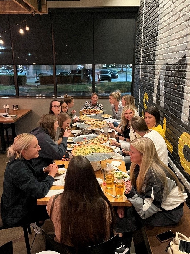 Women's Soccer celebrates 25 years with pizza.