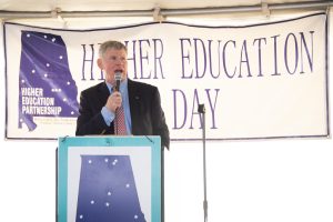 Gordon Stone speaks at Higher Education Day in Alabama in 2024. Stone, seen speaking at the podium and wearing a navy jacket, blue dress shirt and orange tie, will serve as Auburn University at Montgomery's Spring 2025 Commencement speaker.