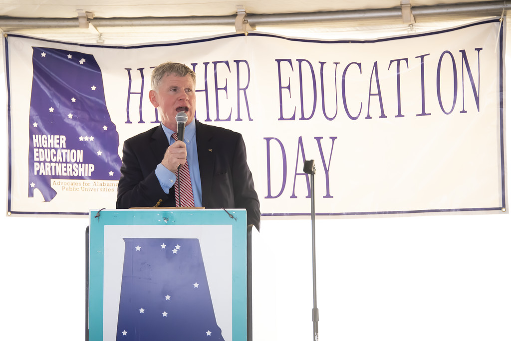 Gordon Stone speaks at Higher Education Day in Alabama in 2024. Stone, seen speaking at the podium and wearing a navy jacket, blue dress shirt and orange tie, will serve as Auburn University at Montgomery's Spring 2025 Commencement speaker.