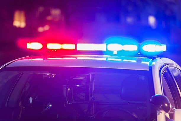 Police car with flashing red and blue lights at night, representing campus safety.