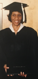 A Graduate In A Cap And Gown Holding A Diploma From Auburn University At Montgomery.