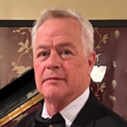A Person In Formal Attire Standing In Front Of A Piano Background.