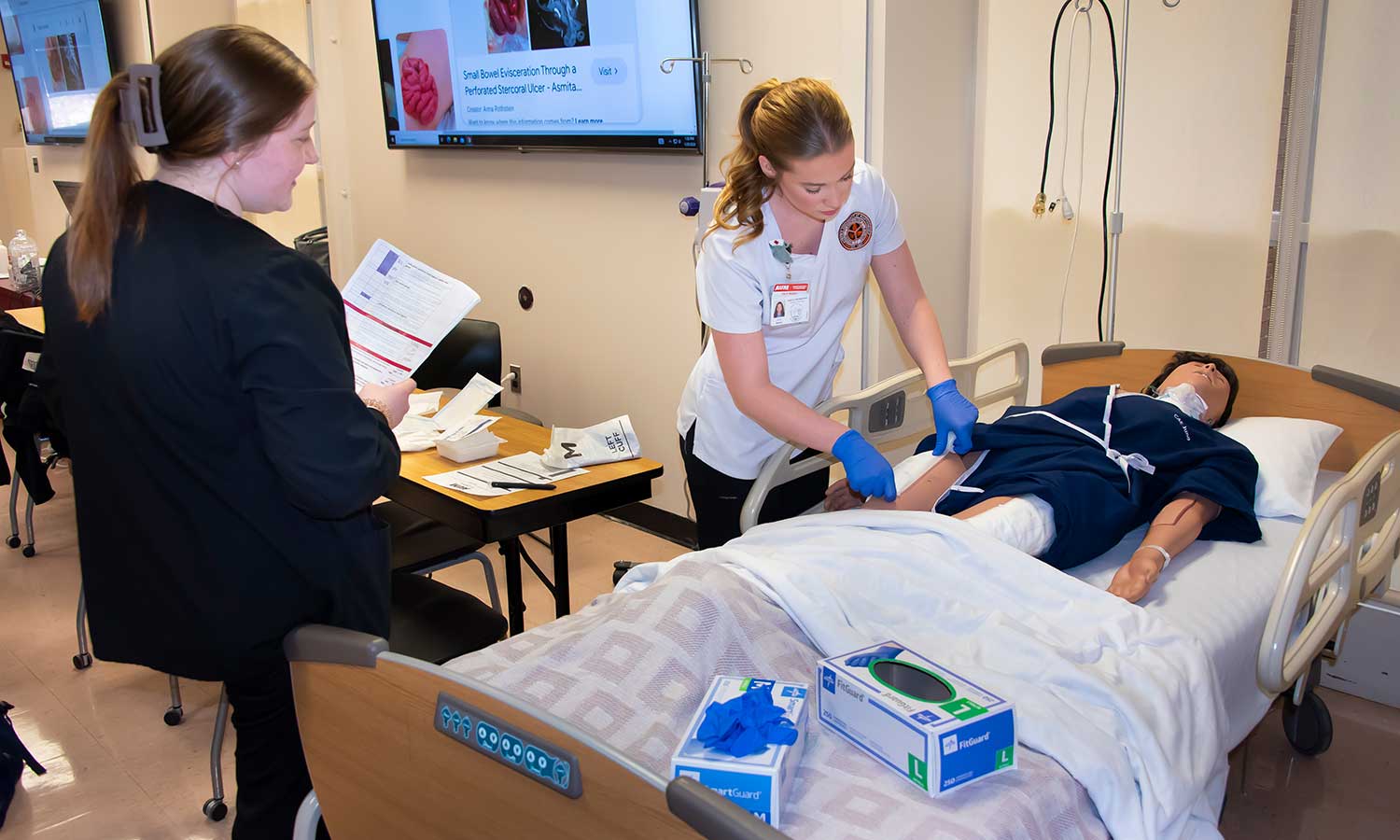 nursing studednt being graded on applying a wound dressing