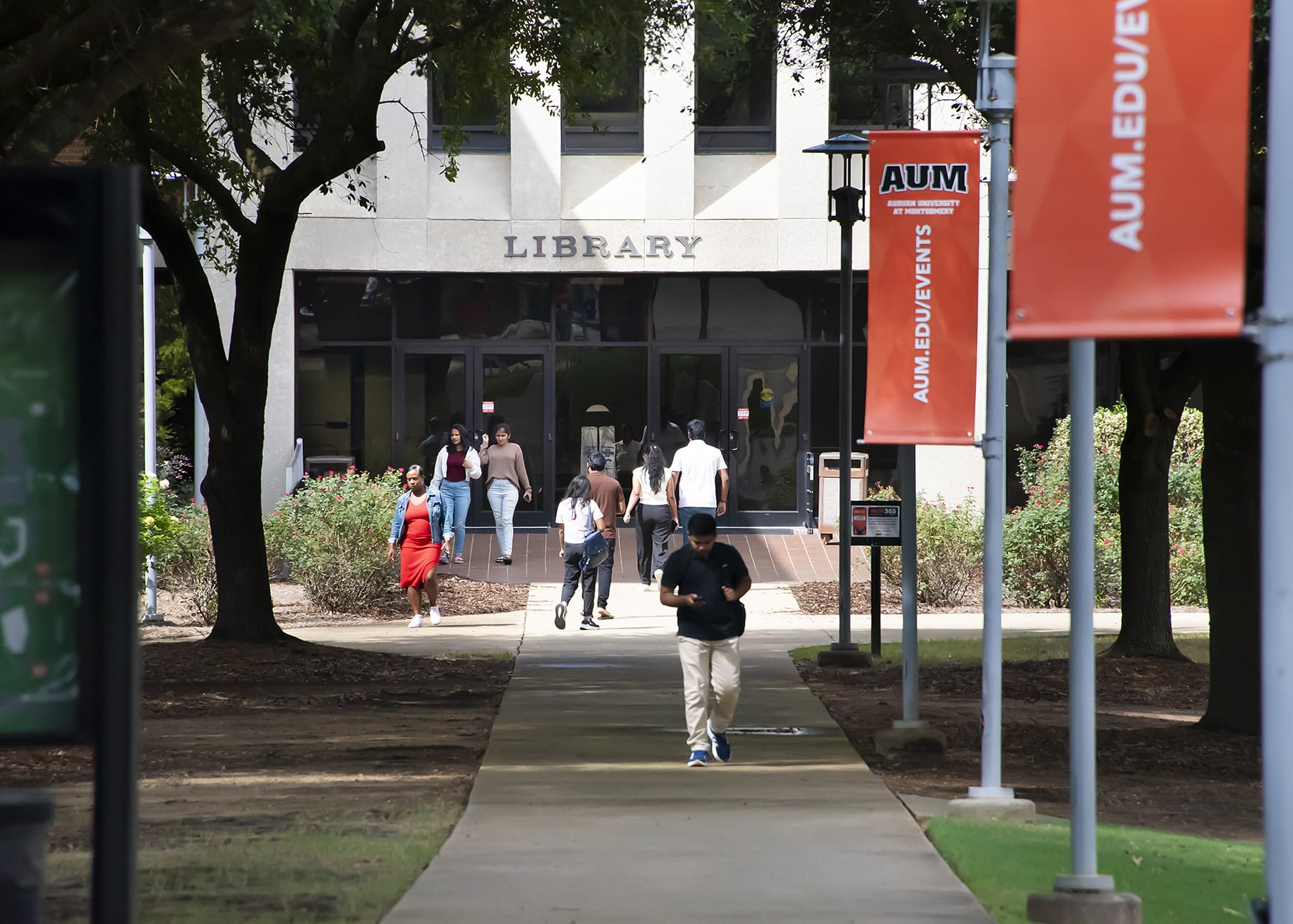 Students walking outside the library at Auburn University at Montgomery campus.