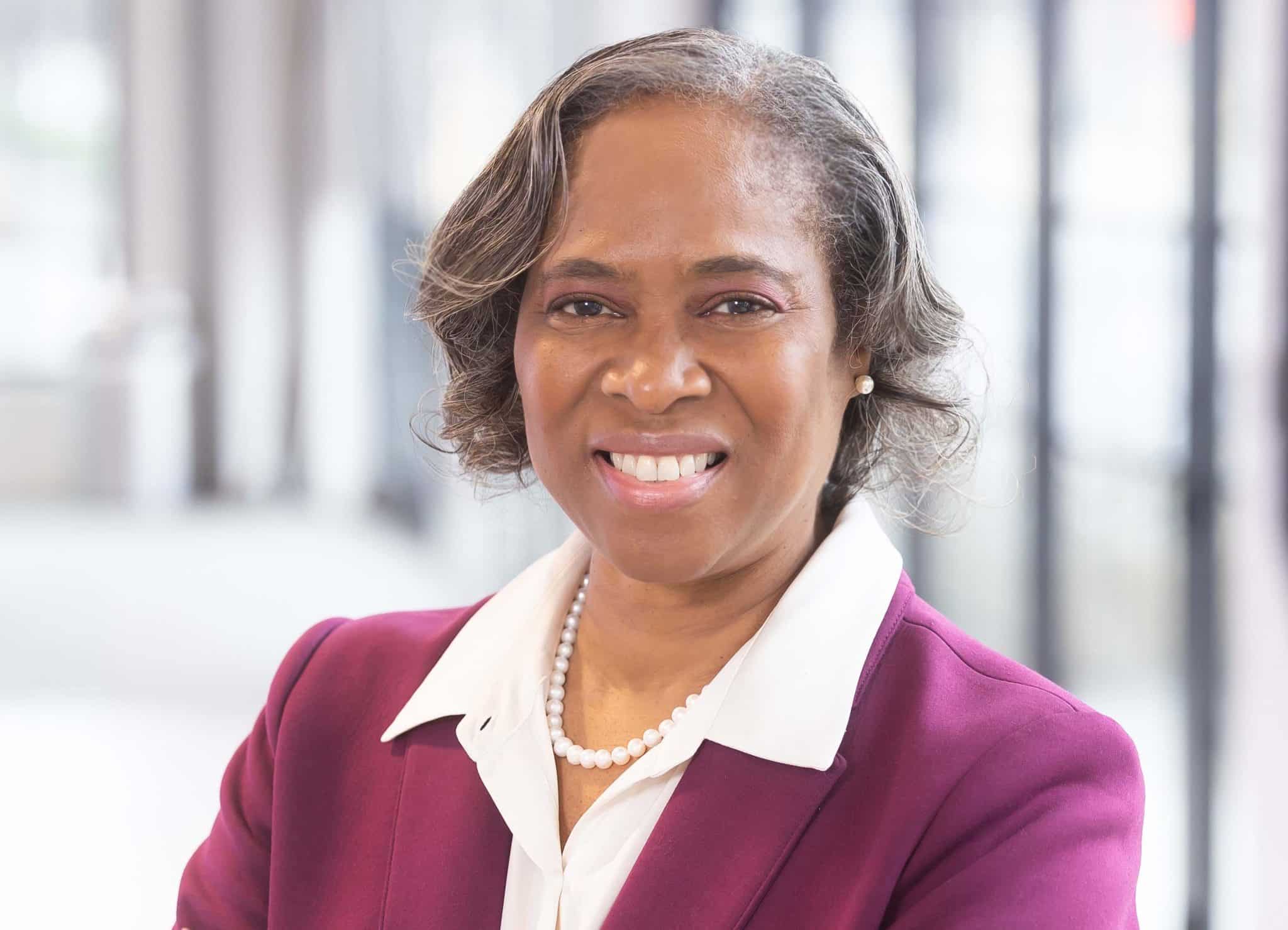 A person in a professional suit smiling at Auburn University at Montgomery campus.