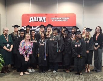 A group of graduates and faculty at Auburn University at Montgomery celebration event.
