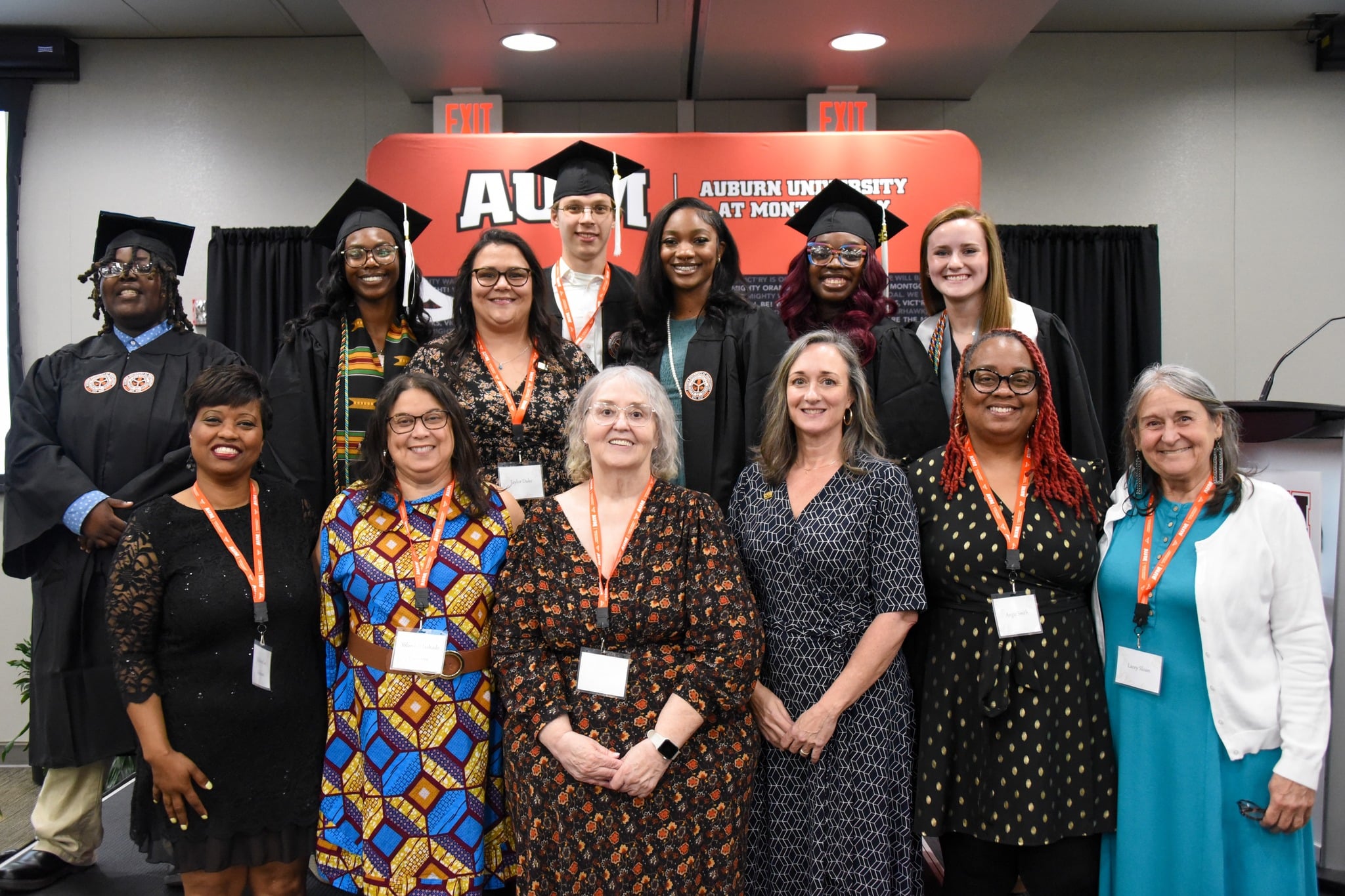 A group of graduates and faculty smiling at an Auburn University at Montgomery event.
