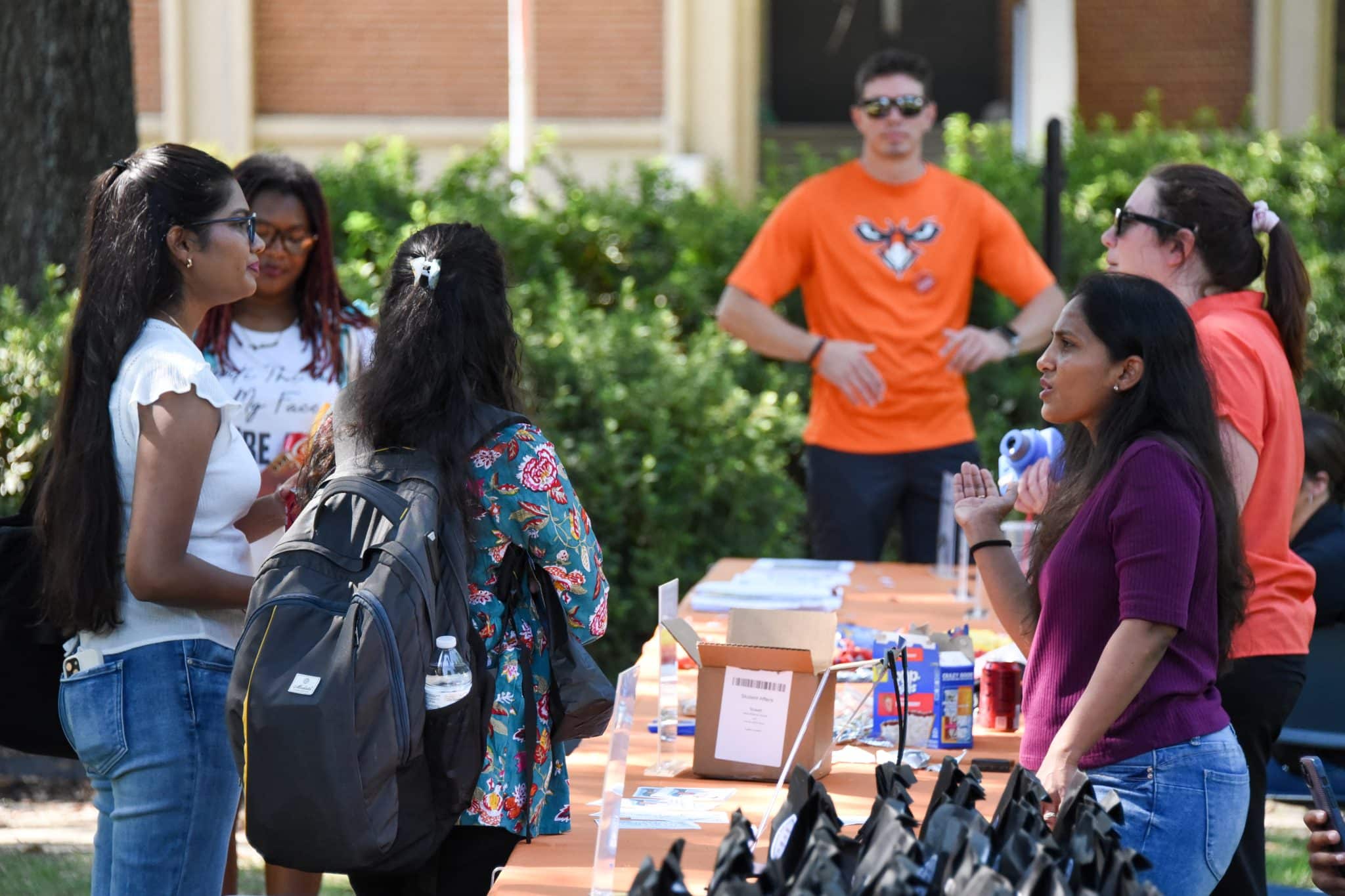 Students engaging at an Auburn University at Montgomery outdoor event table.