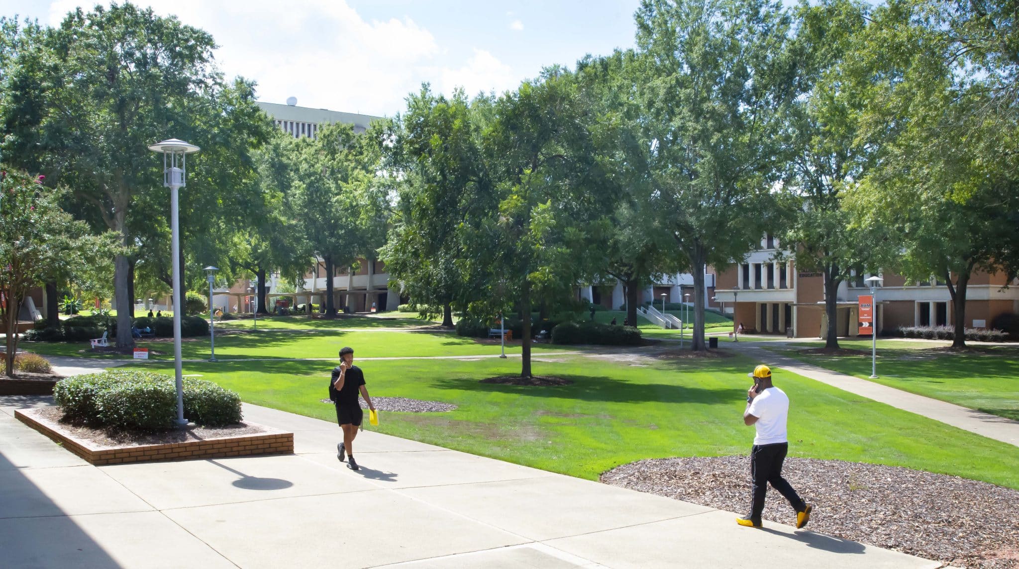 Auburn University at Montgomery campus with two people walking on a sunny day.