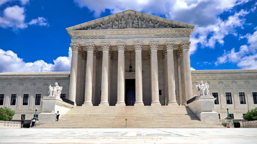 The United States Supreme Court Building With Its Grand Pillars And Steps Under A Blue Sky.