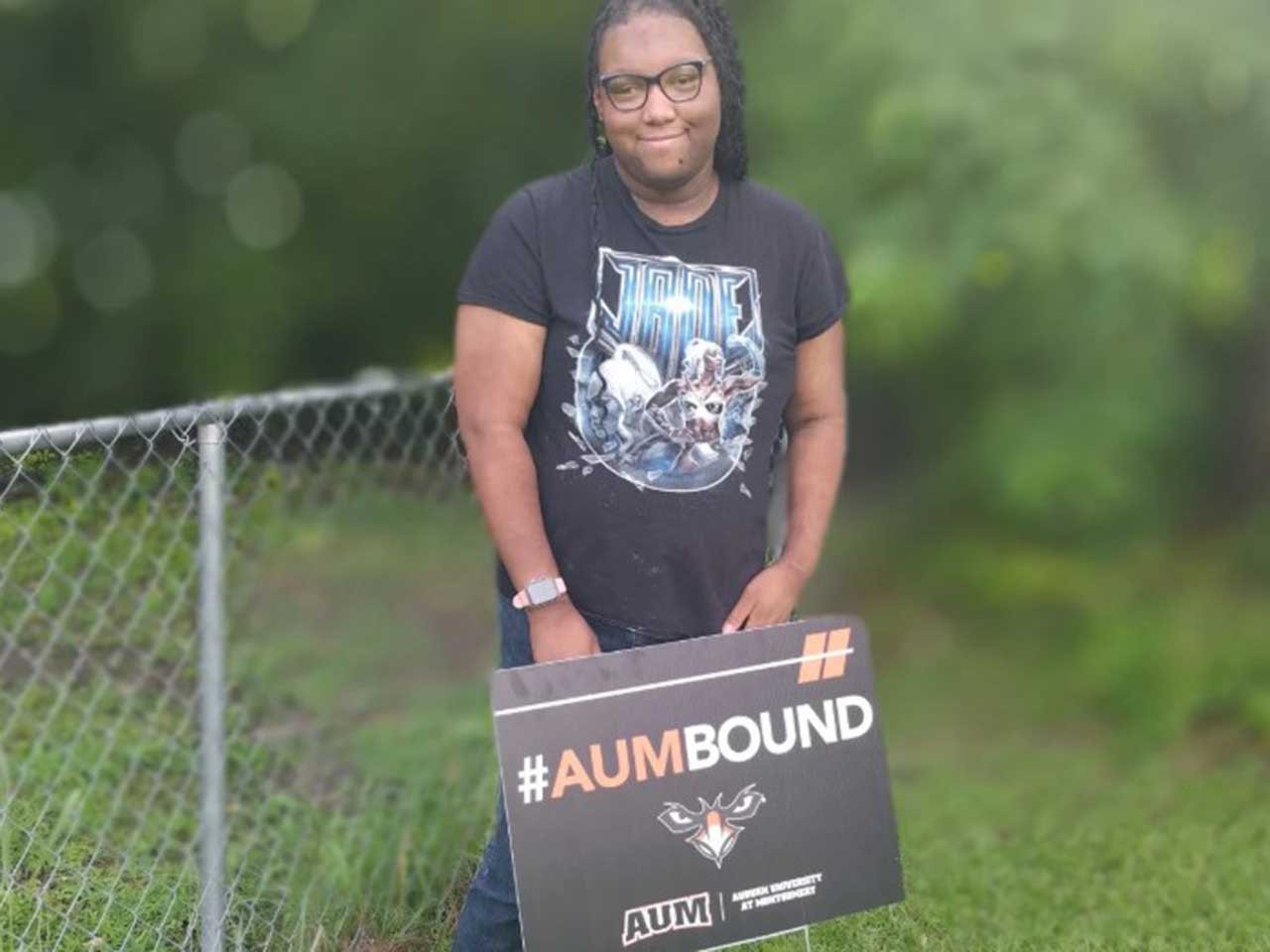 A person holding an #AUMBOUND sign for Auburn University at Montgomery.
