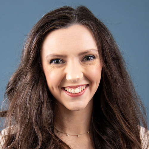 A smiling woman with long brown hair against a blue background at Auburn University at Montgomery.
