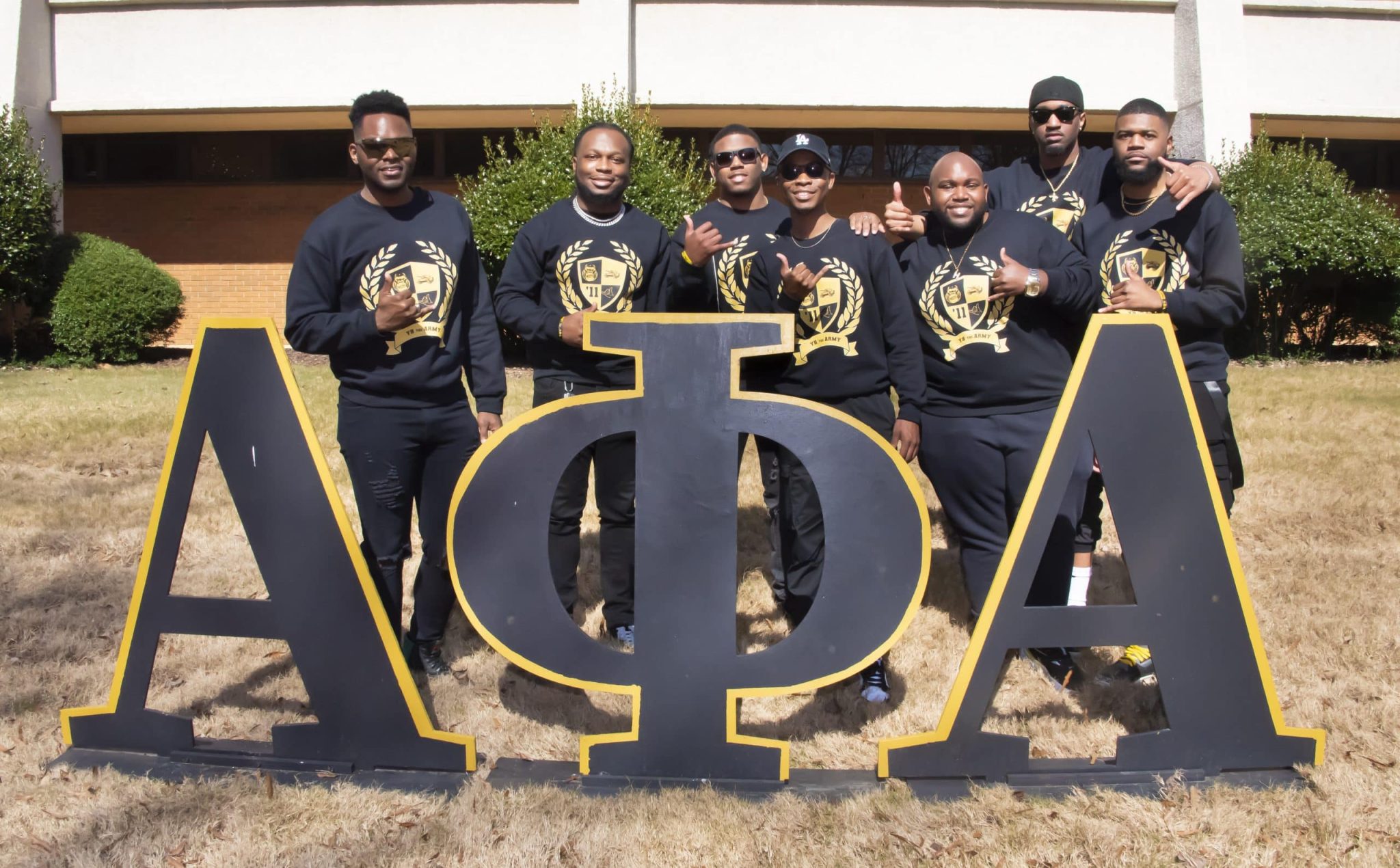 Auburn University at Montgomery students in Alpha Phi Alpha fraternity sweatshirts with large APA letters on campus.