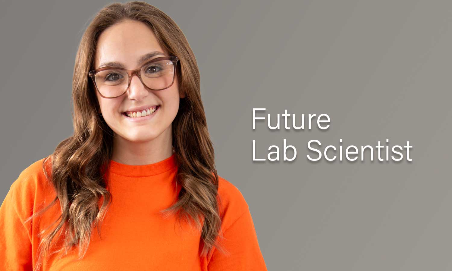 Auburn University at Montgomery student in orange shirt and glasses, smiling, future lab scientist