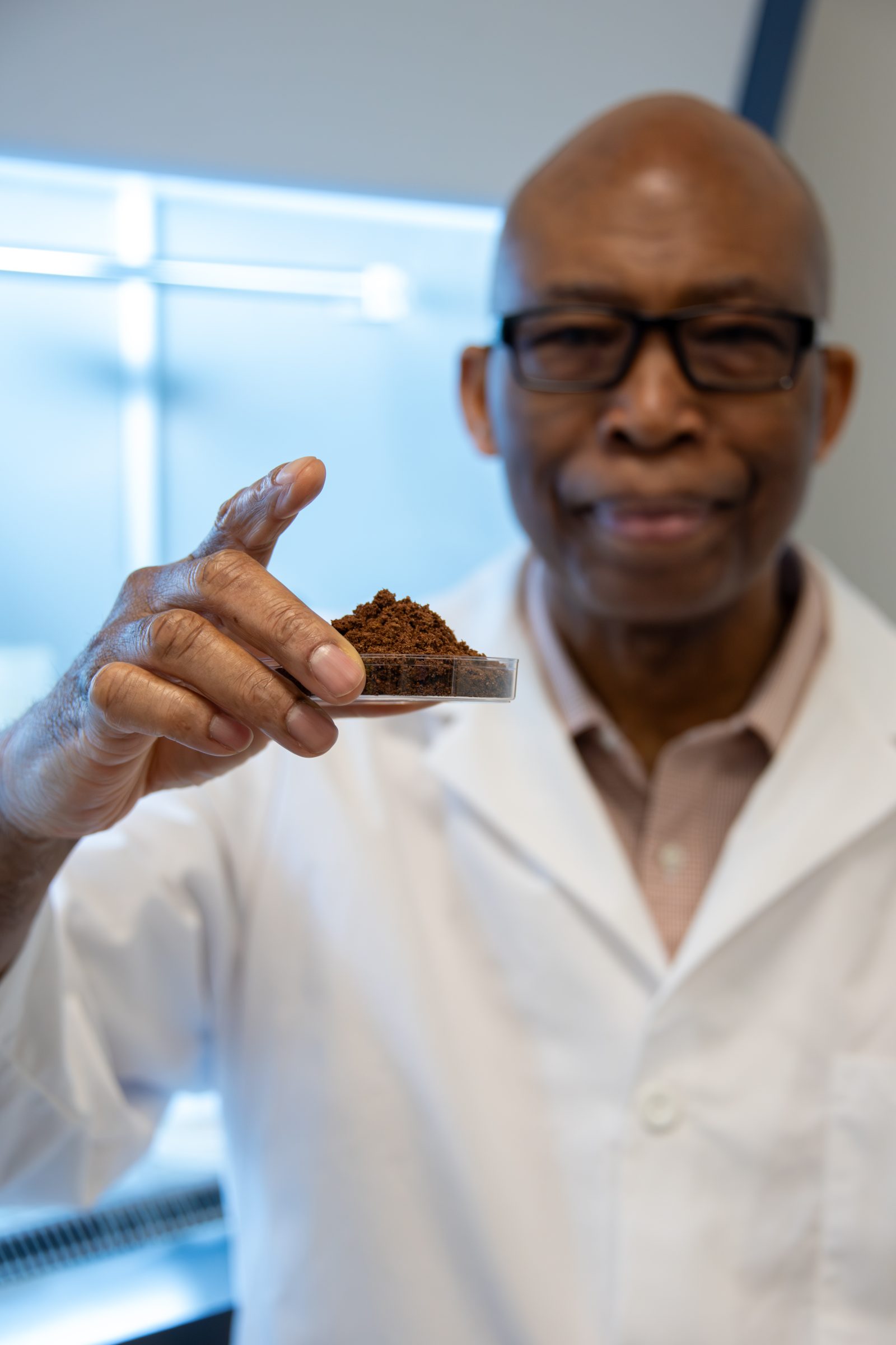 Auburn University at Montgomery researcher holds soil sample in a petri dish in campus lab