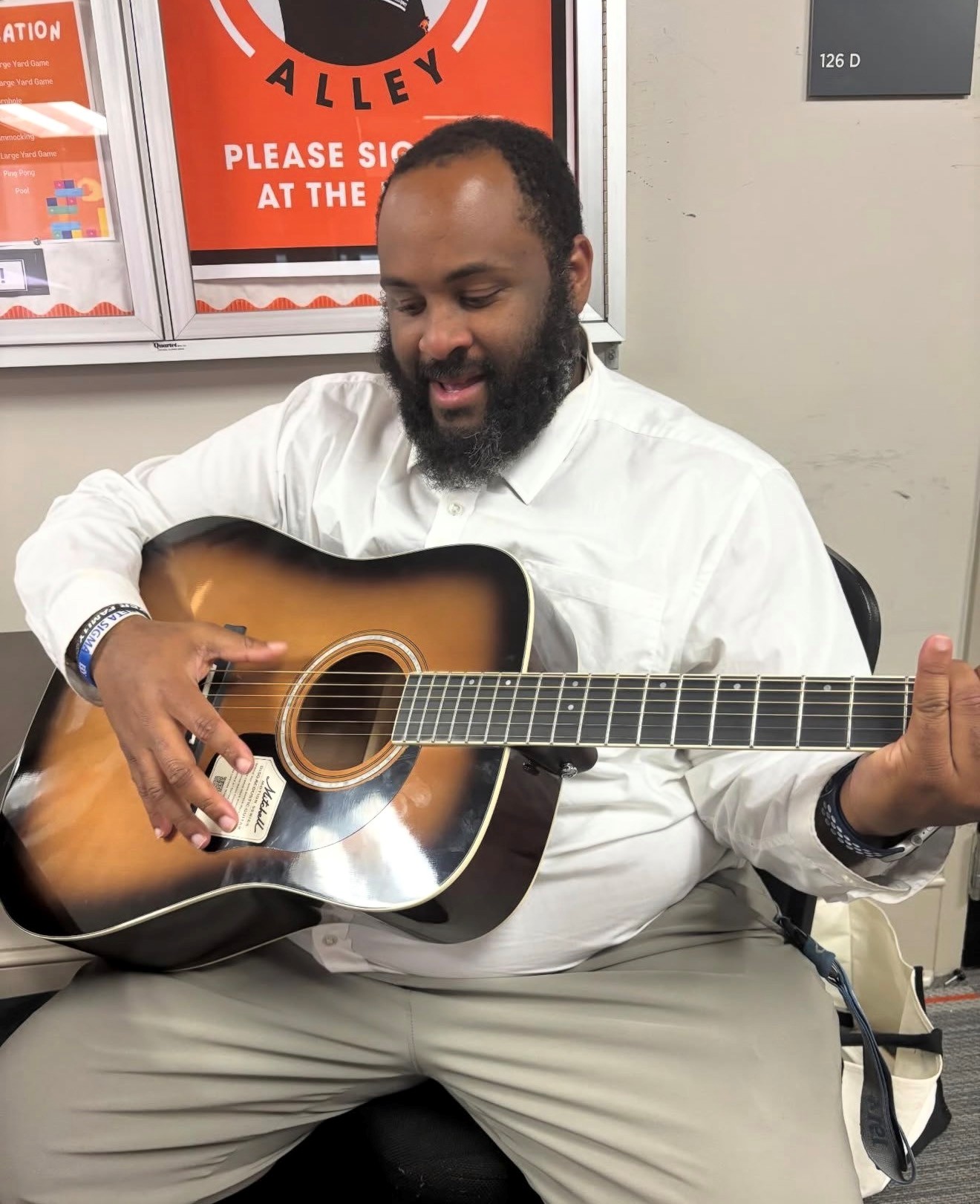 Da'Monta Wiggins, Director of Student Life, plays acoustic guitar in Warhawk Alley
