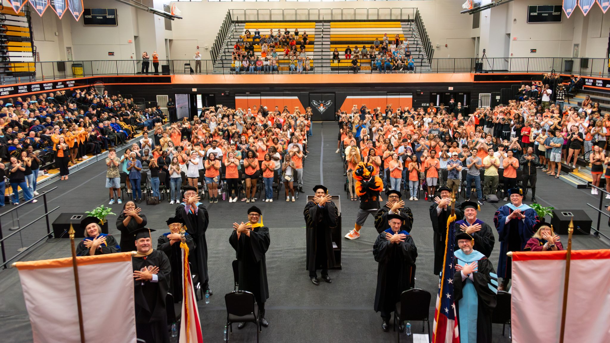 Auburn University at Montgomery students and faculty pack the Athletics Complex for New Student Convocation, posing for the photographer with the Warhawk symbol.