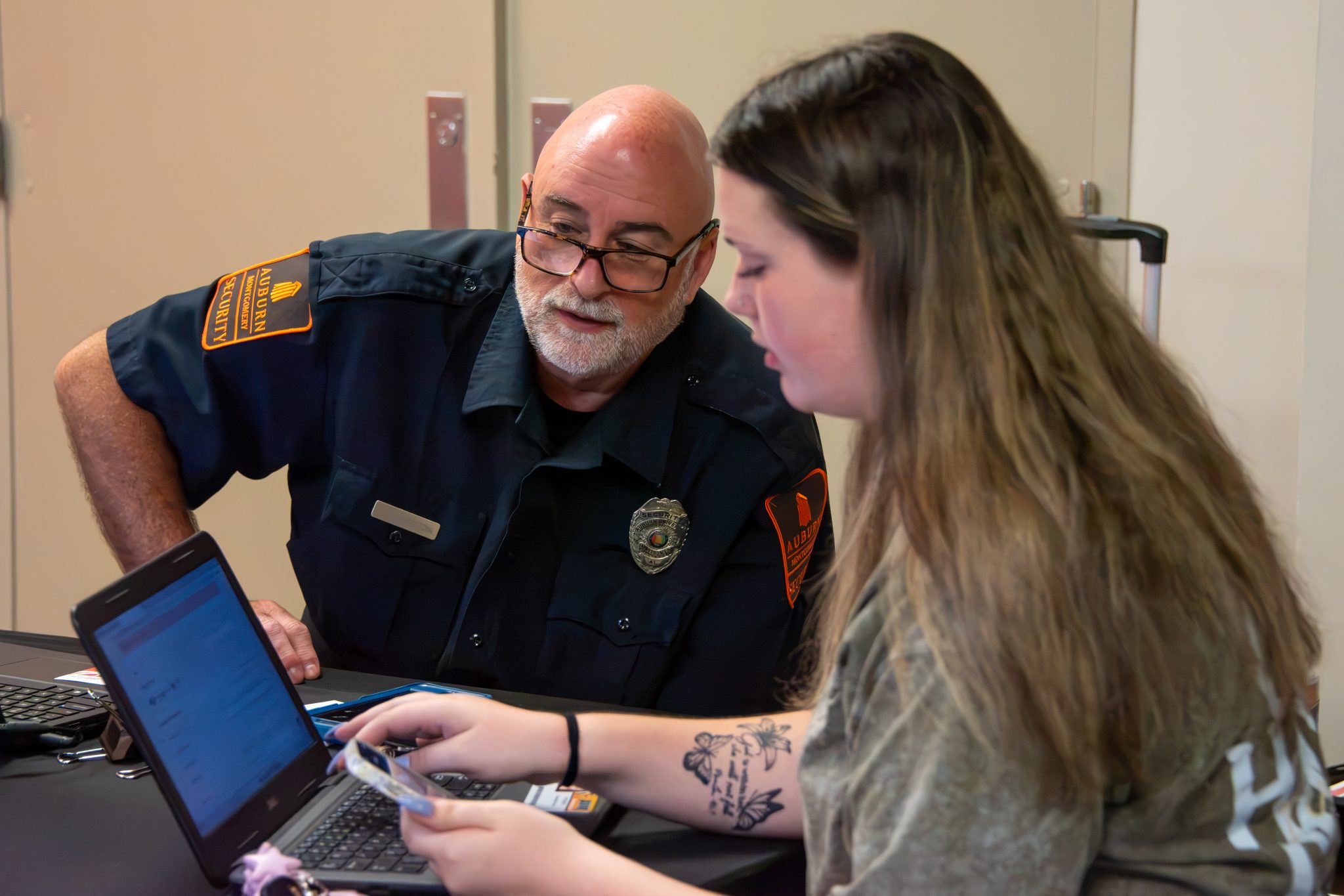 AUM officer helps students register their car for parking decals.