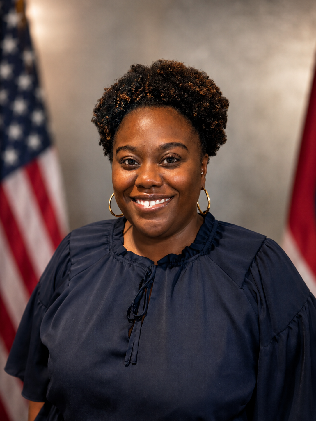 Auburn University at Montgomery portrait of a woman smiling in navy blouse with American flag in background