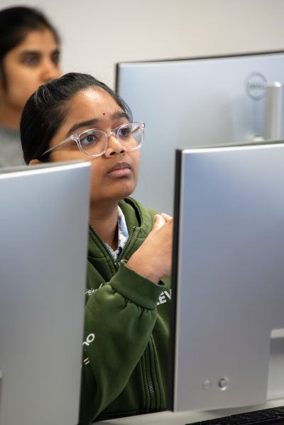 Auburn University at Montgomery student focused on a desktop computer in a technology lab classroom